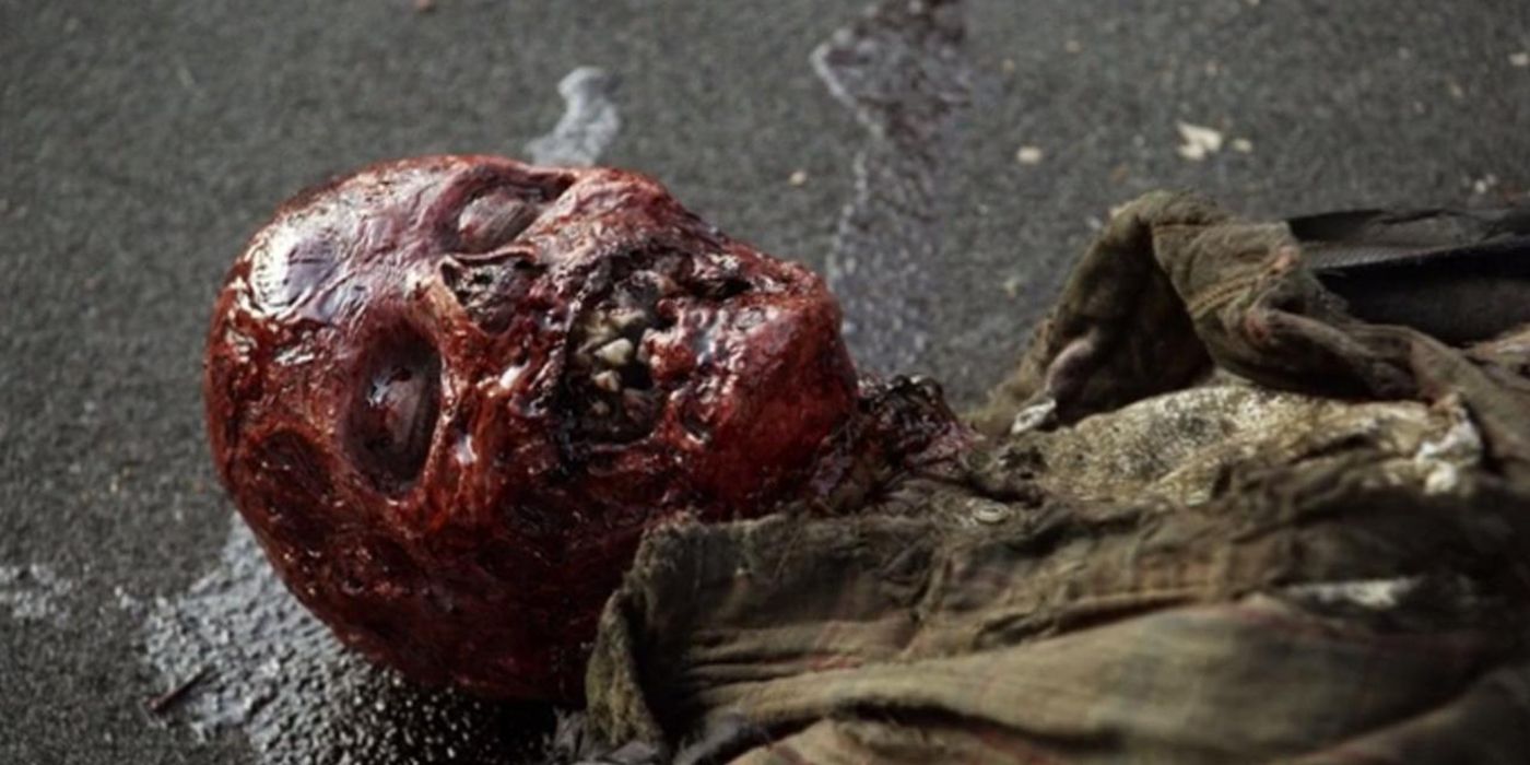 A walker on the ground with its facial skin pulled off, looking red on The Walking Dead