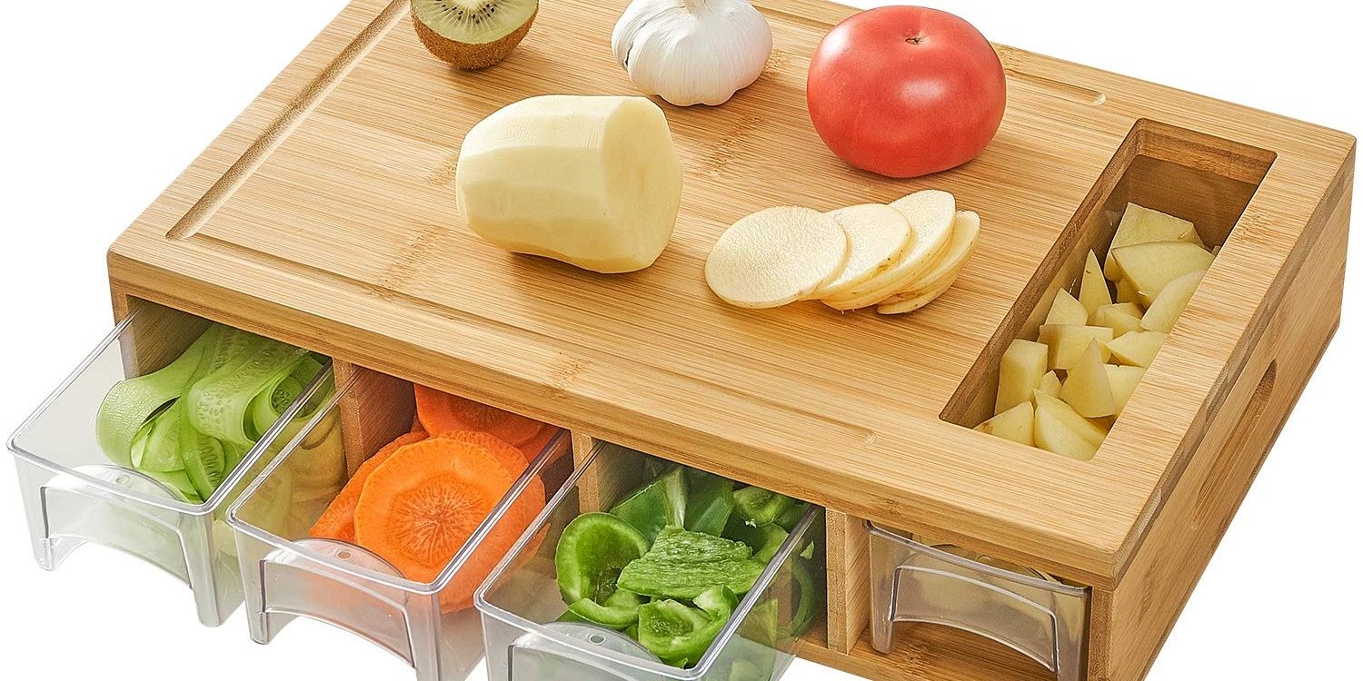 Wood cutting board with plastic containers holding cut vegetables