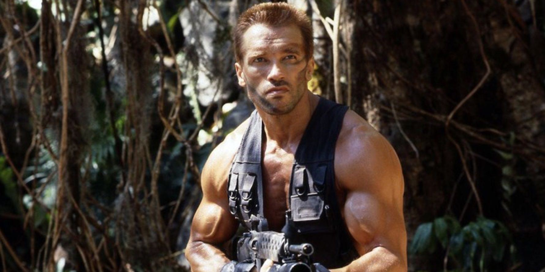 Arnold Schwarzenegger with a big gun in the jungle in Predator