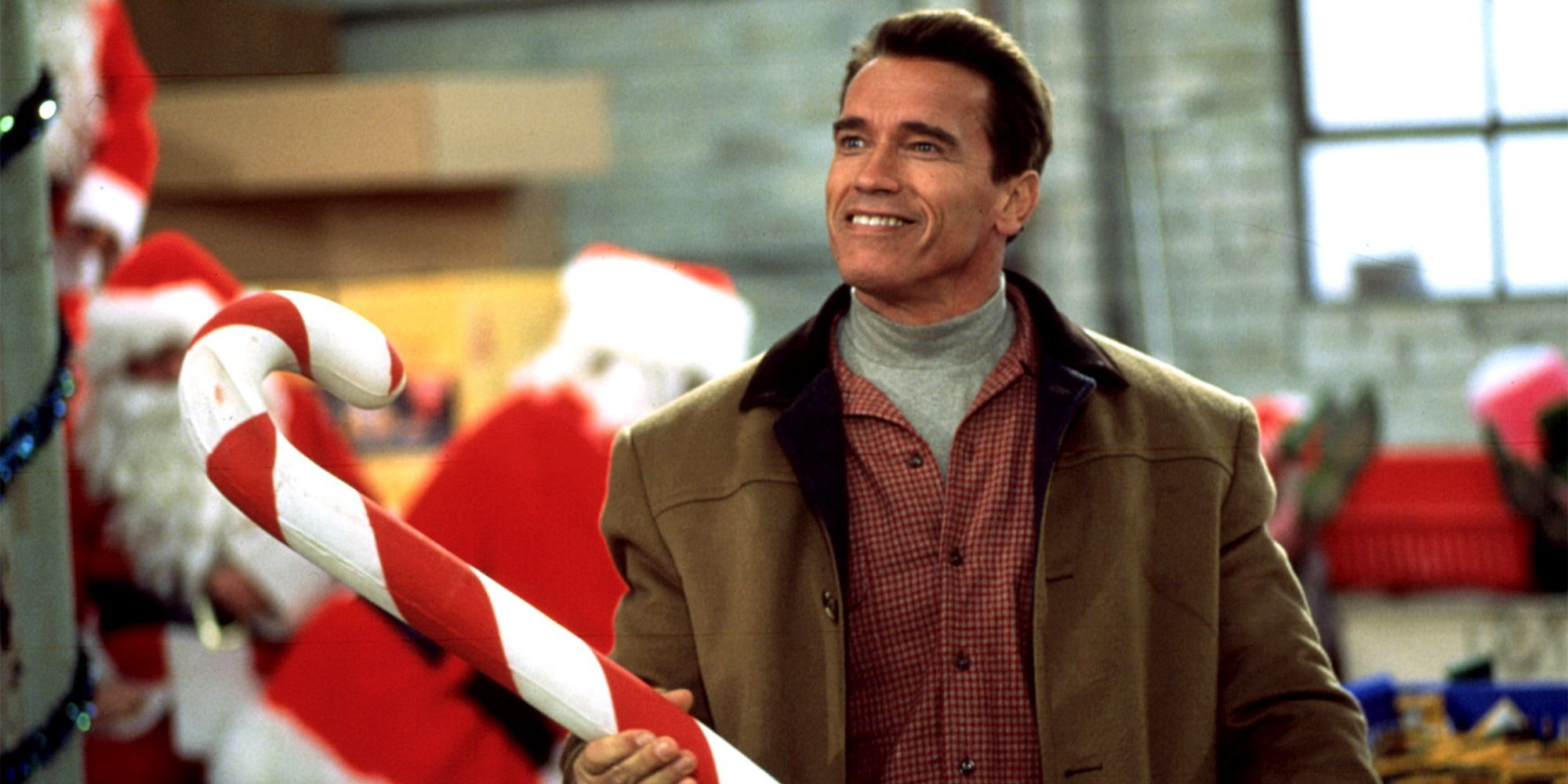 Arnold Schwarzenegger avec une canne en bonbon géante dans Jingle All the Way