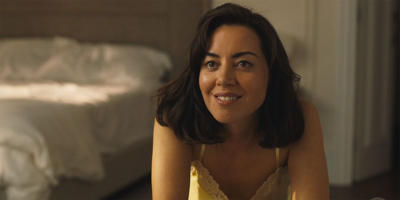 Aubrey Plaza smiling while leaning over in The White Lotus season 2