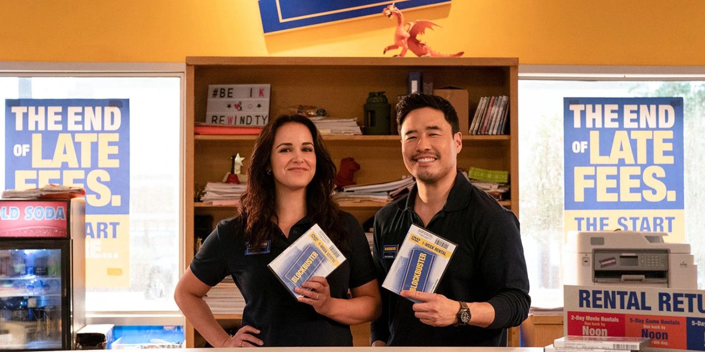 Melissa Fumero and Randall Park smiling and standing inside a Blockbuster score