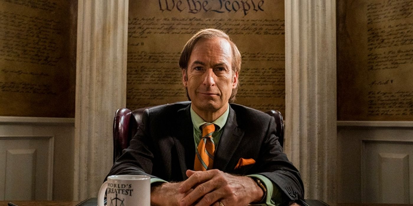 Bob Odenkirk sorrindo em sua mesa em Better Call Saul.