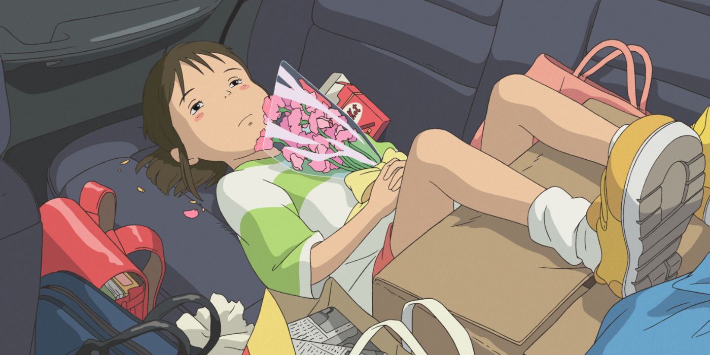 Chihiro berbaring di belakang mobil sambil memegang bunganya di Spirited Away