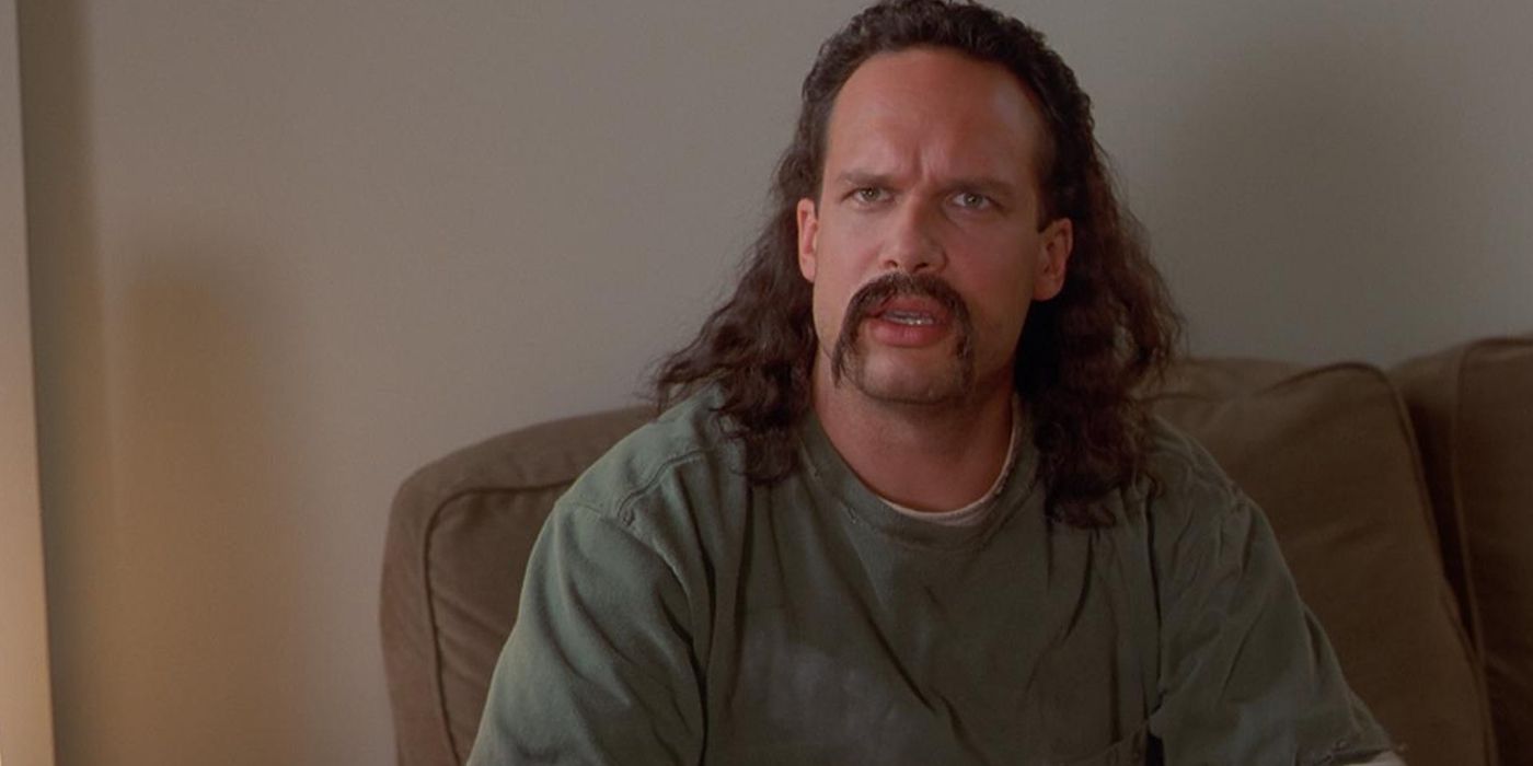 Diedrich Bader sitting on a coach in Office Space