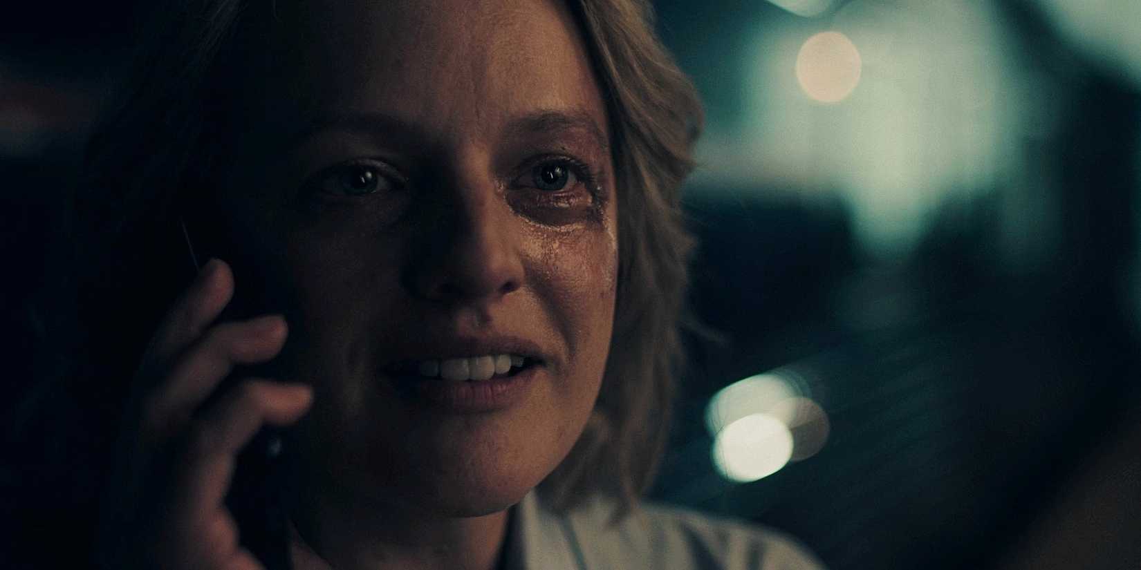 A beaten up June Osborne (Elisabeth Moss) on a phone in The Handmaid's Tale.
