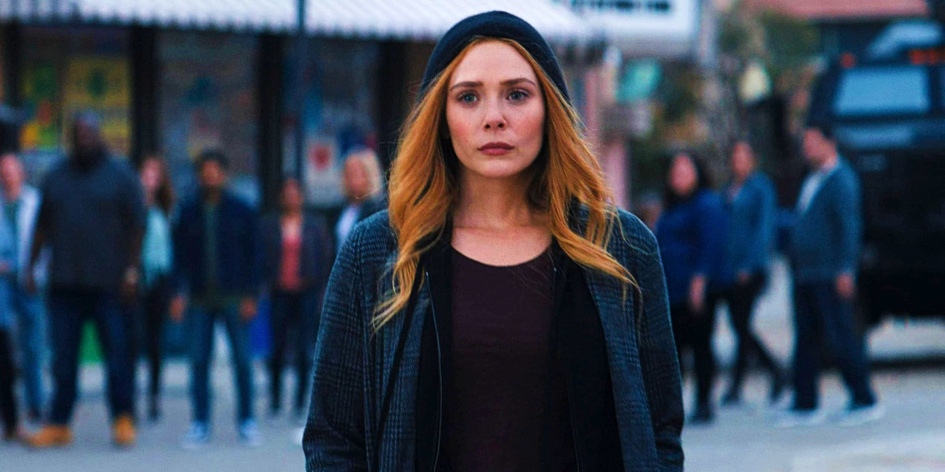 Elizabeth Olsen como Wanda Maximoff Feiticeira Escarlate em pé na rua Westview no final da WandaVision