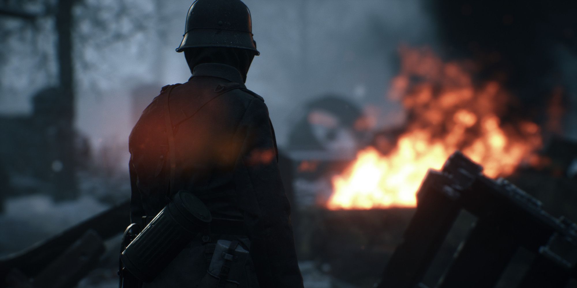 Um soldado olhando para um campo de batalha em chamas em Hell Let Loose.