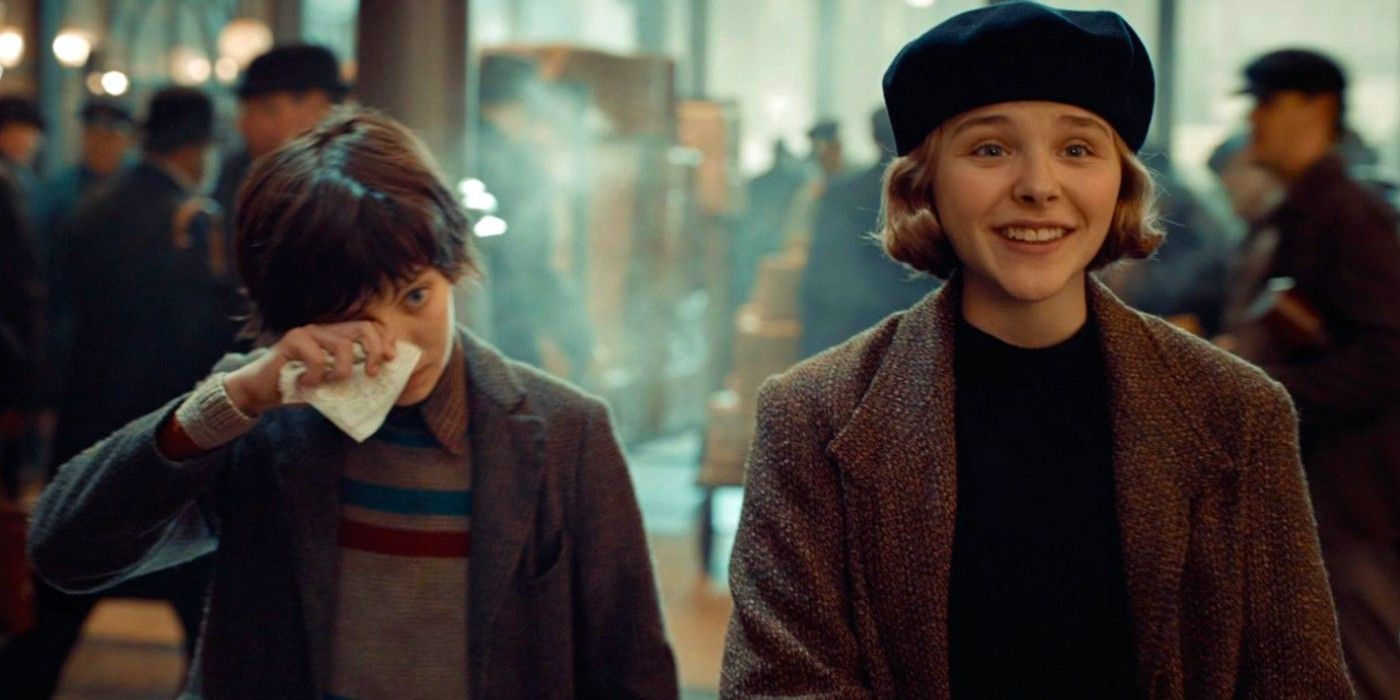 Chloë Grace Moretz smiling and Asa Butterfield wiping his eyes in Hugo