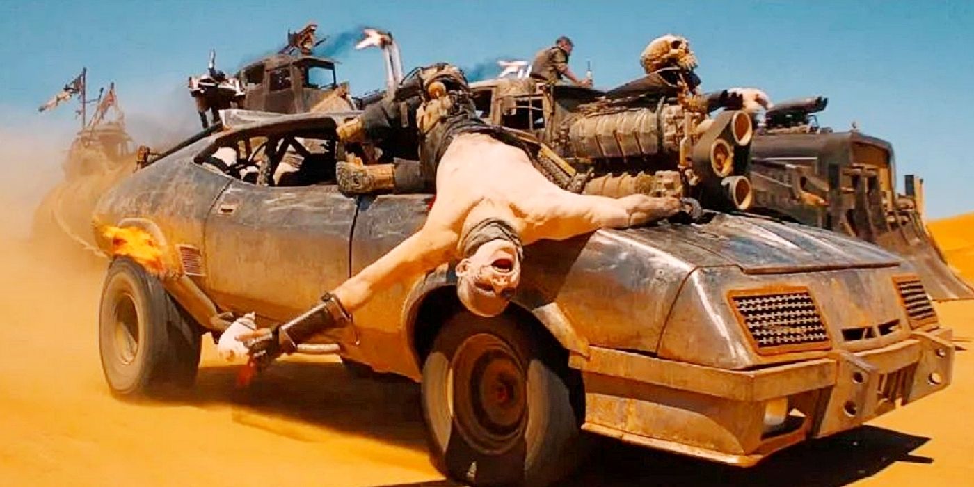 A War Boy hangs off a moving muscle car in Mad Max: Fury Road.