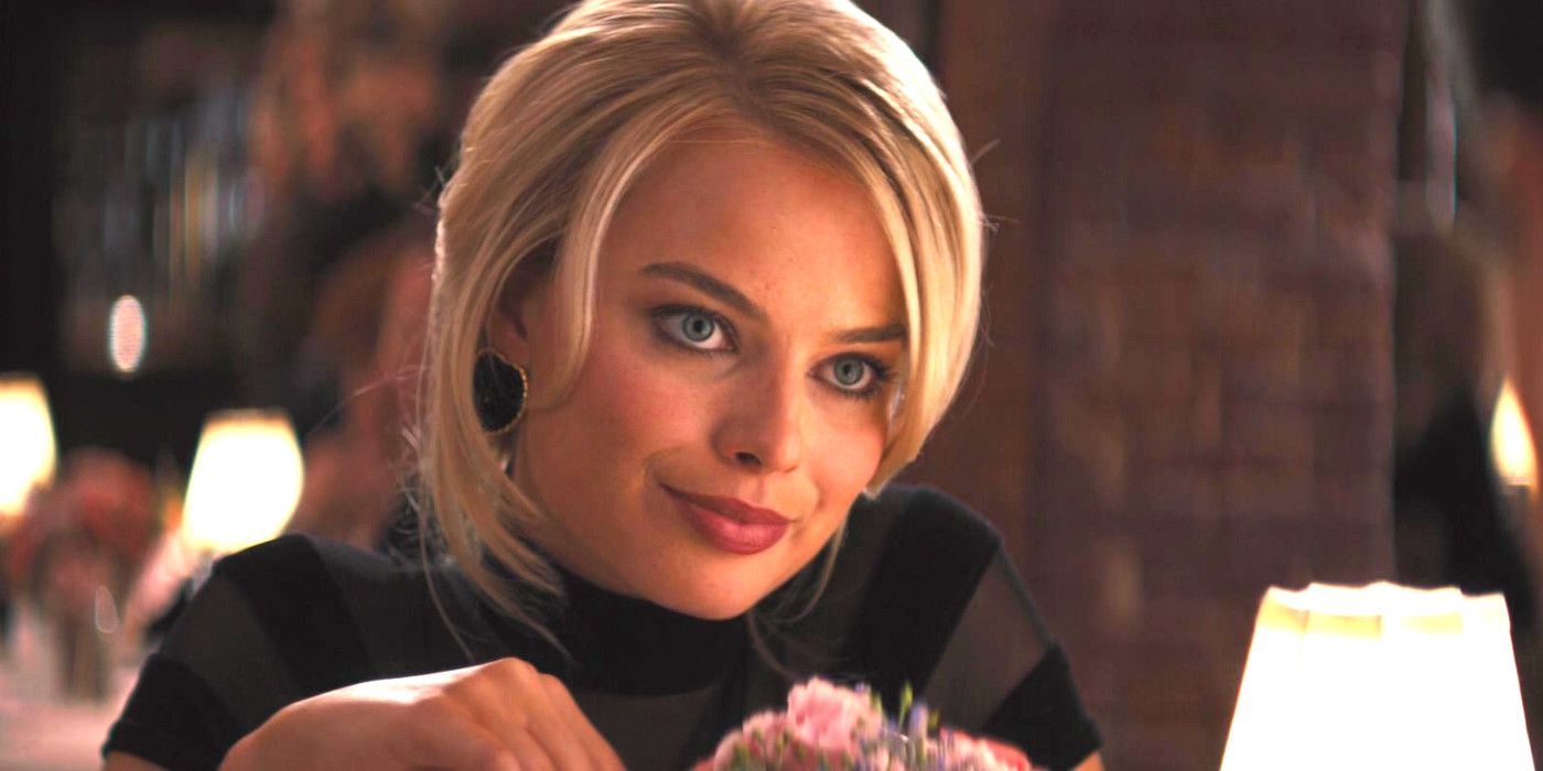 Margot Robbie as Naomi in The Wolf of Wall Street having dinner in a fancy restaurant, sly expression on her face