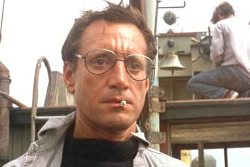 Roy Scheider In Jaws looking shocked on a boat with eyeglasses on and a cigarette dangling from his lips