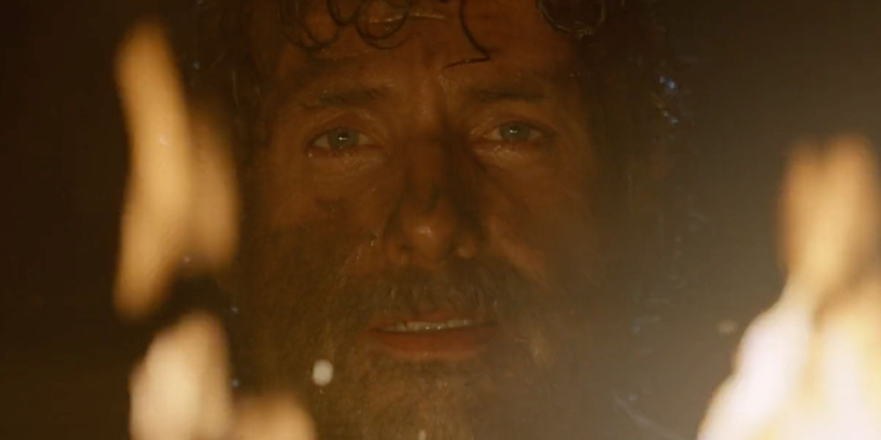 Rick Grimes looks into a fire in The Walking Dead