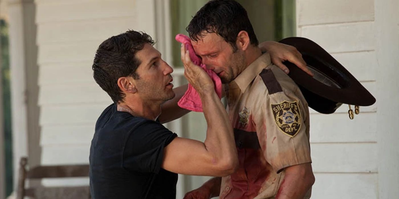 Shane menyeka wajah Rick dengan kain lap saat dia menangis dan berlumuran darah di season 2 The Walking Dead. 
