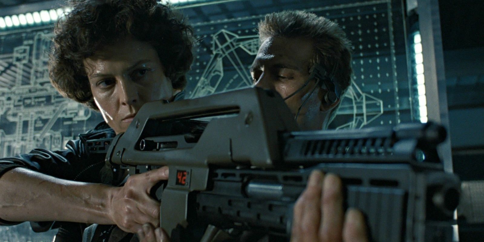 Sigourney Weaver and Michael Biehn holding a gun in Aliens