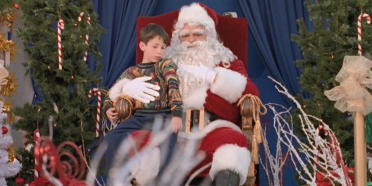 Uma criança senta-se no colo do Papai Noel de uma loja de departamentos em Sliders: Season's Greedings.