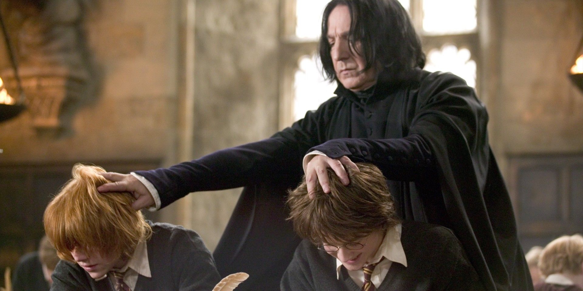 Snape empurrando as cabeças de Rony e Harry para baixo em Harry Potter e o Cálice de Fogo