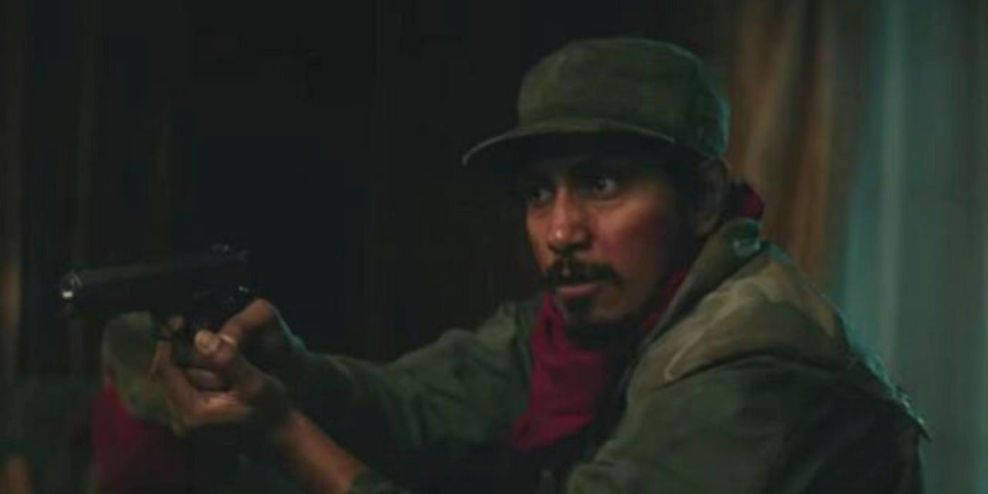 Tenoch Huerta holding a gun in Bel Canto