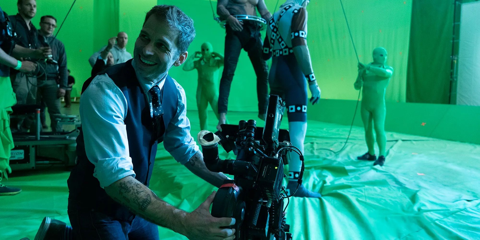 Zack Snyder operating a camera in front of a greenscreen.