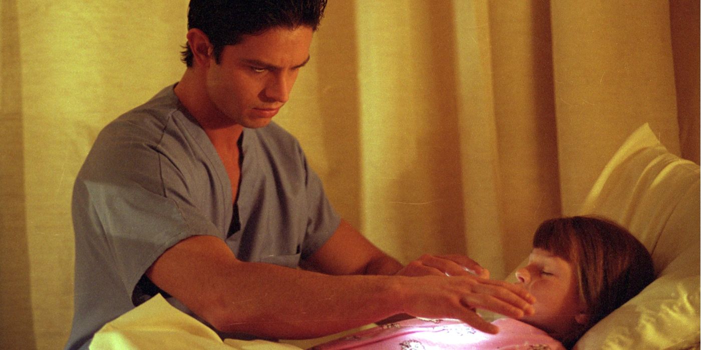 Max curando uma criança em uma cama de hospital em um episódio de Natal de Roswell. 
