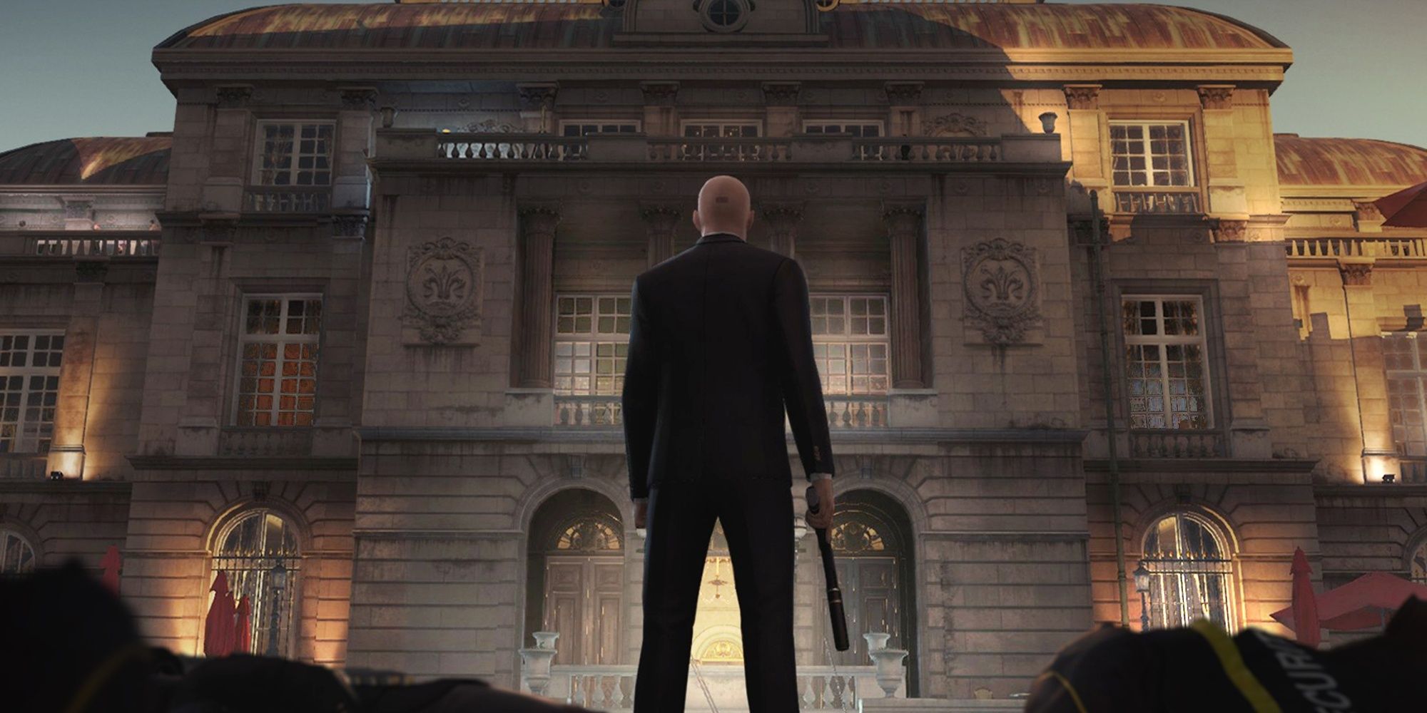 Agent 47 looking at a mansion in Hitman 2016 