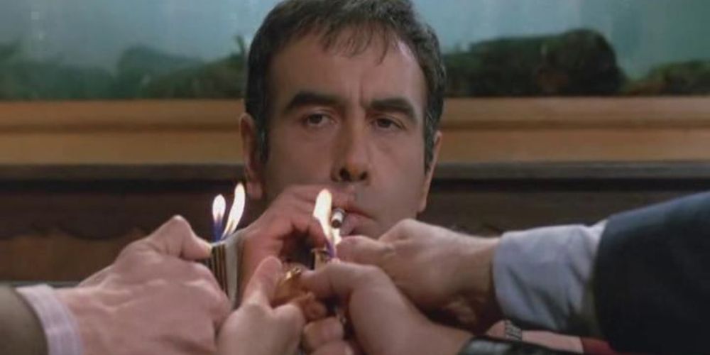 Anthony Castelo's handlangers steken sigaretten voor hem op (Wise Guys)