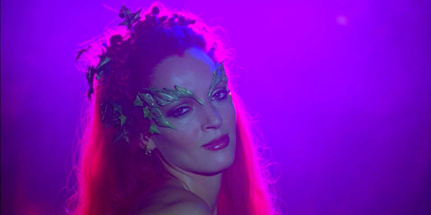 Uma Thurman as Poison Ivy smiling and bathed in purple light in Batman & Robin