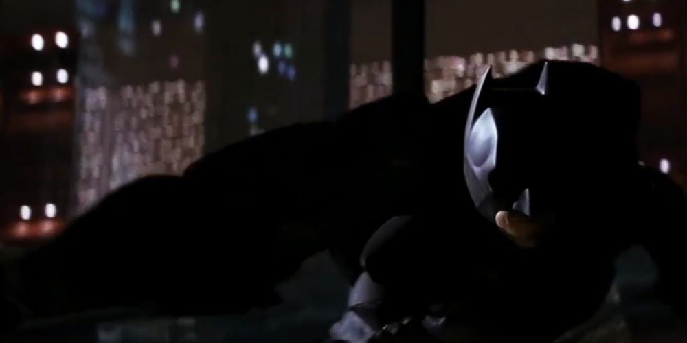 Batman desliza por um prédio em O Cavaleiro das Trevas