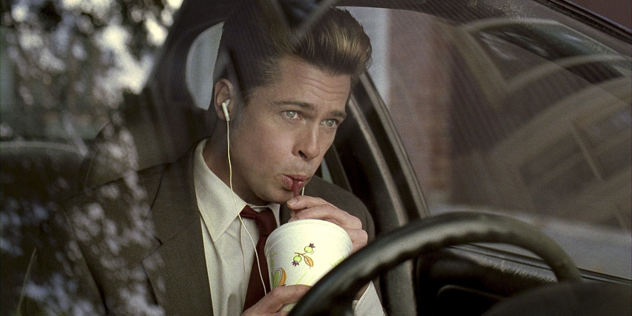 Brad Pitt bebendo uma raspadinha em um carro em Burn After Reading 