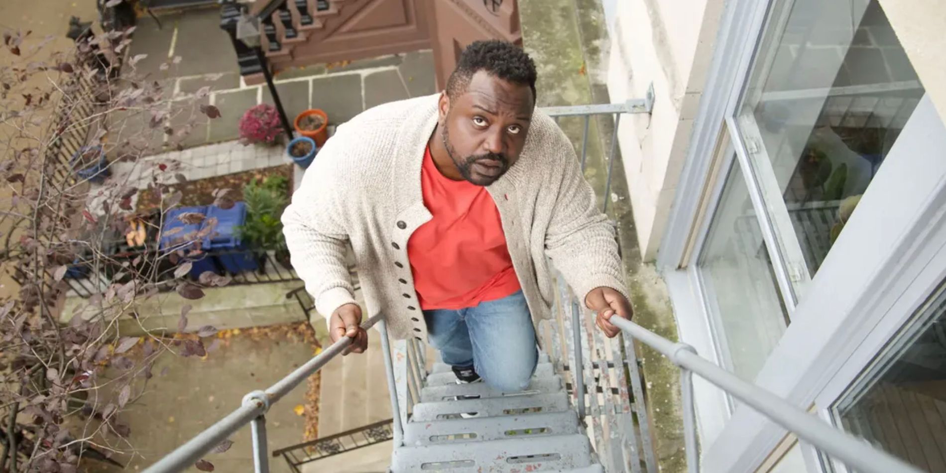 Brian Tyree Henry escalando una escalera de incendios en Outside Story