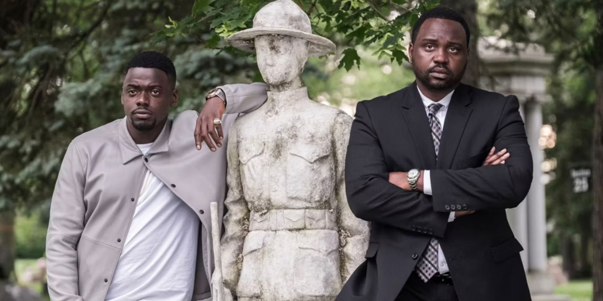 Daniel Kaluuya and Brian Tyree Henry on either side of a statue in Widows