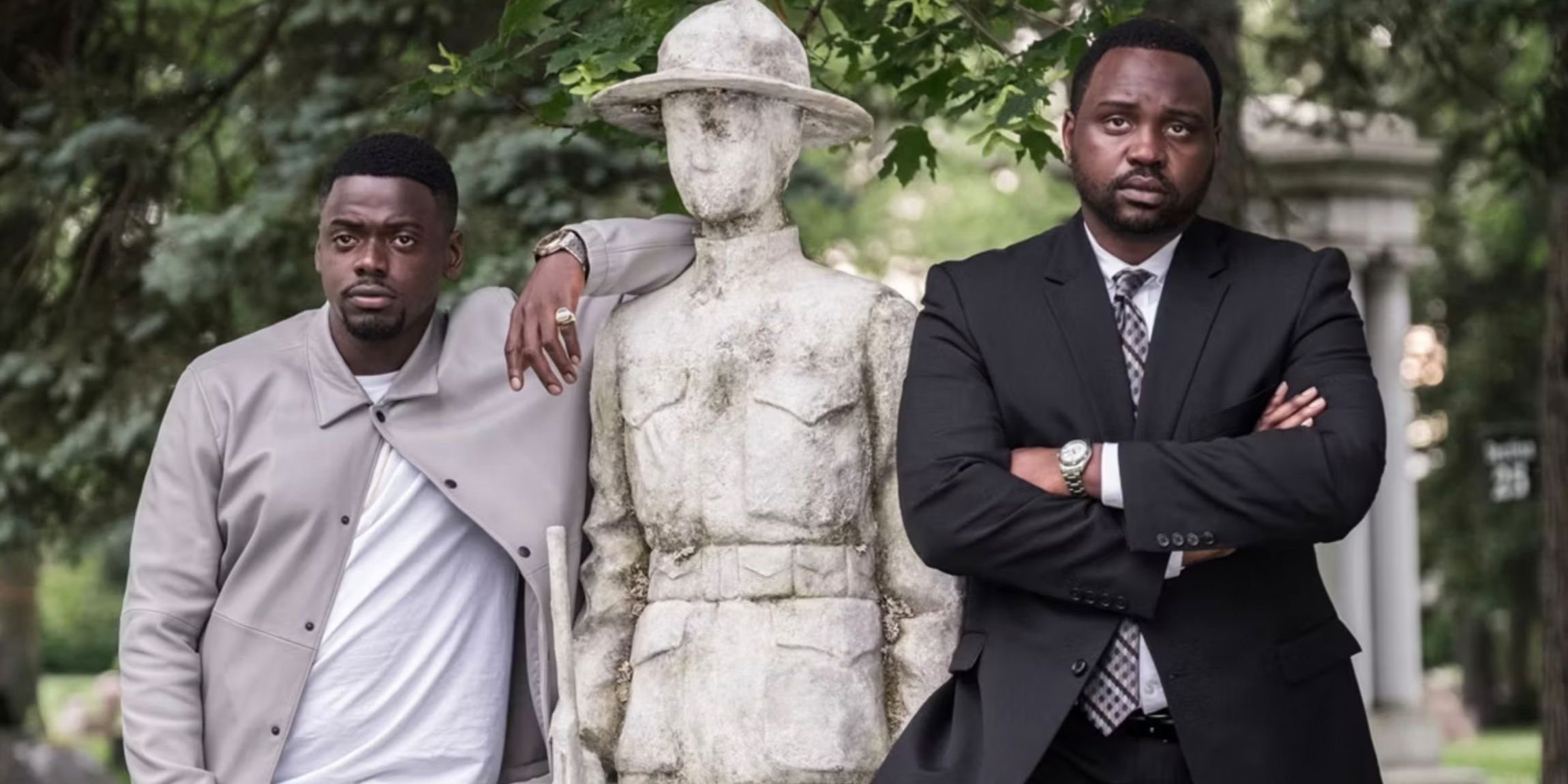 Daniel Kaluuya y Brian Tyree Henry a ambos lados de una estatua en Viudas