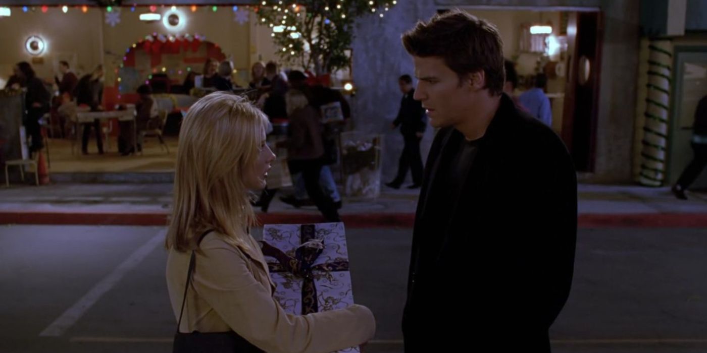 Buffy holding a Christmas present in her hand talking to Angel in the street in Buffy the Vampire Slayer. 