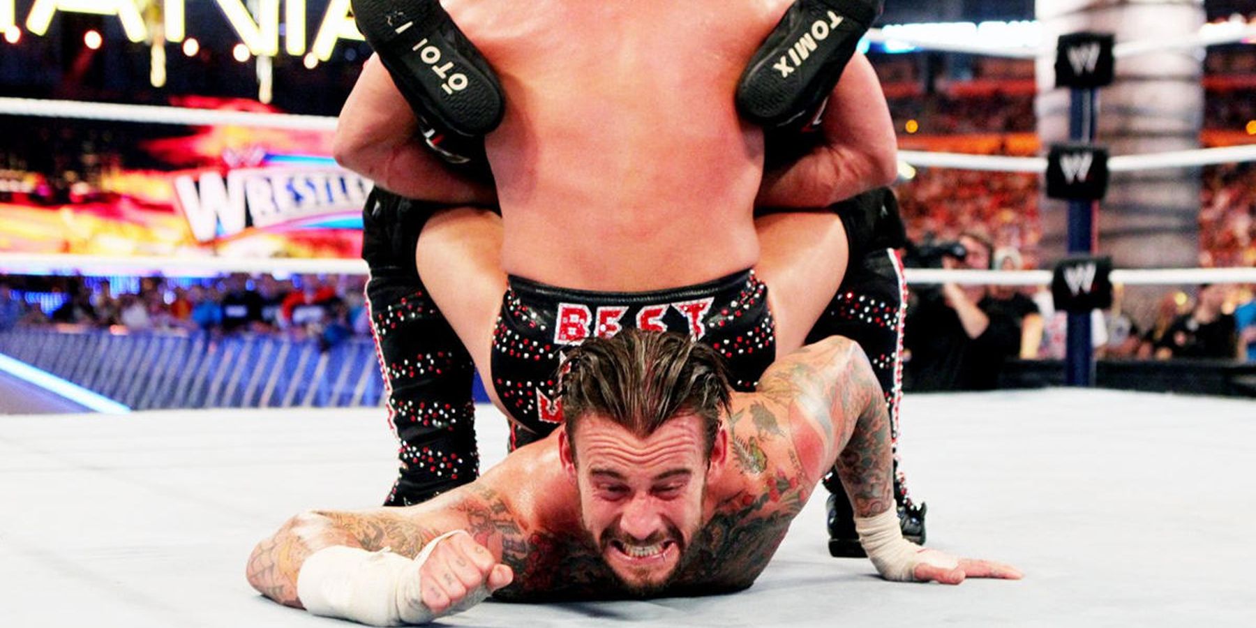 Chris Jericho locks CM Punk into a submission hold during WrestleMania when both men were in WWE.
