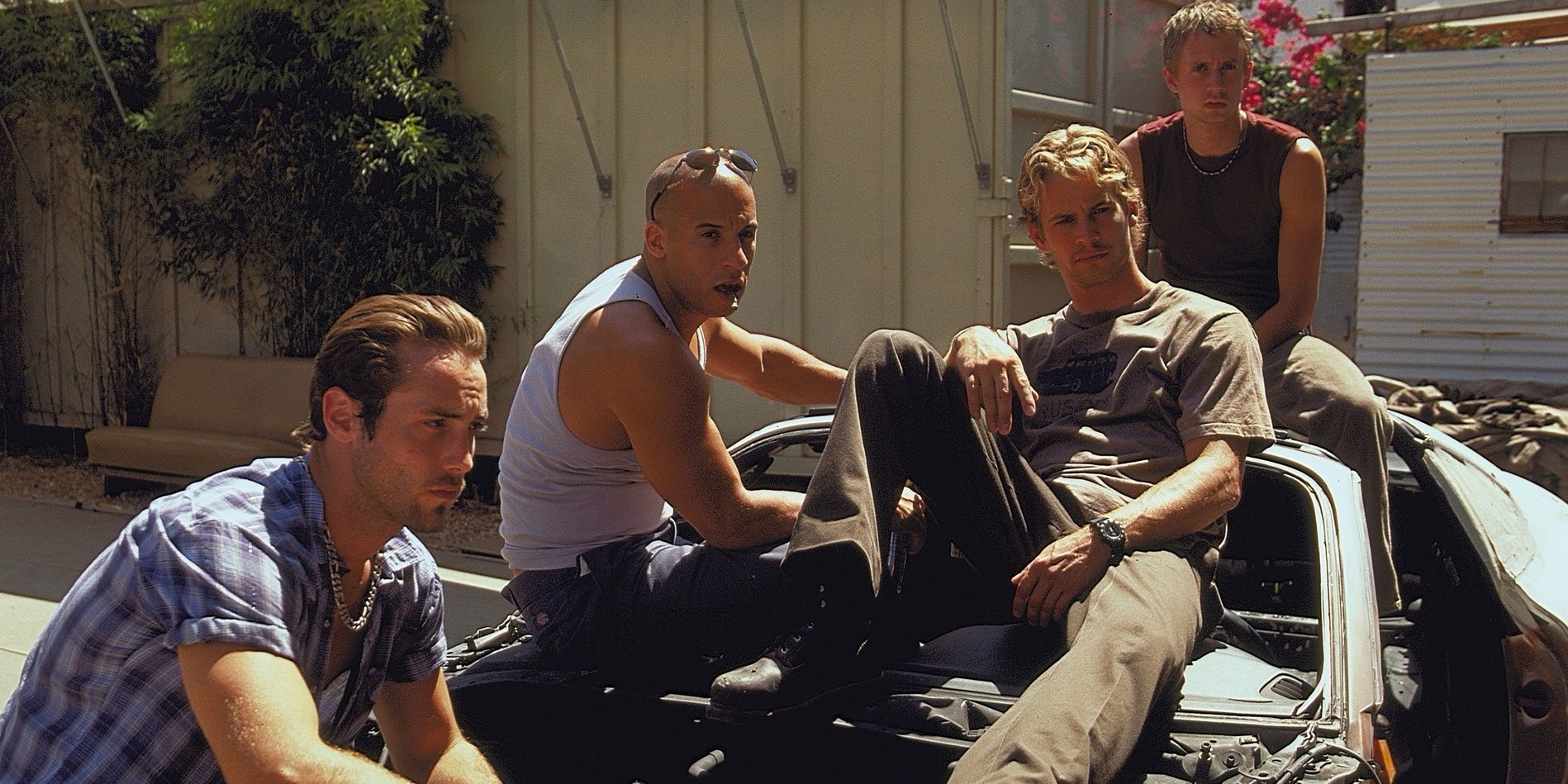 Dom and Brian sitting on a car with their friends in The Fast and the Furious 