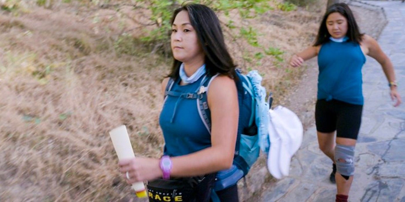 Emily and Molly from The Amazing Race 34 with serious faces walking down a hill.