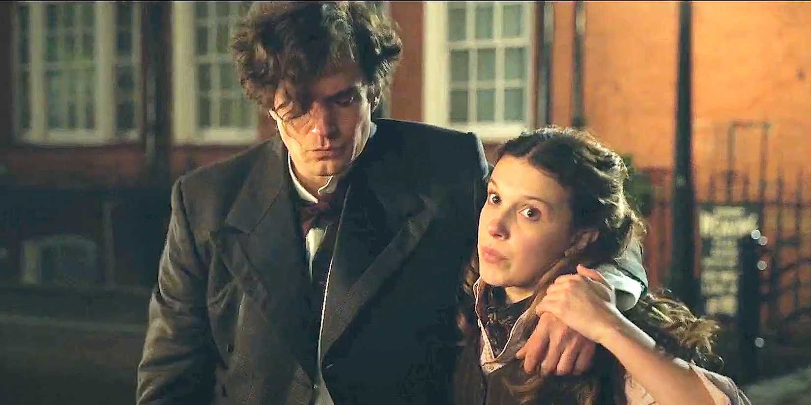 Enola (Millie Bobby Brown) helping a drunk Sherlock Holmes (Henry Cavill) walk in Enola Holmes..