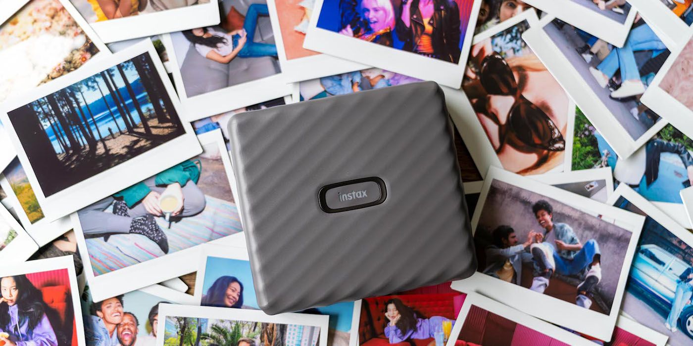 fujifilm instax link wide instant printer with a collage of photos in the background.