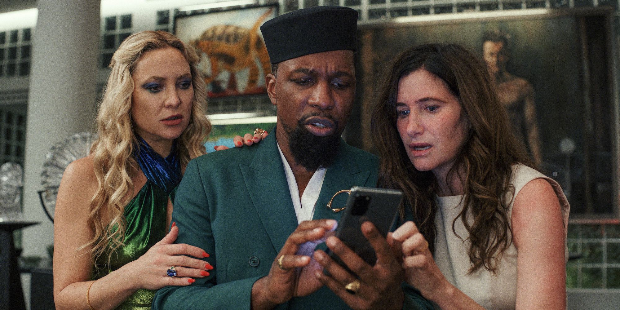 Lionel looks through his phone with Claire and Birdie in Glass Onion