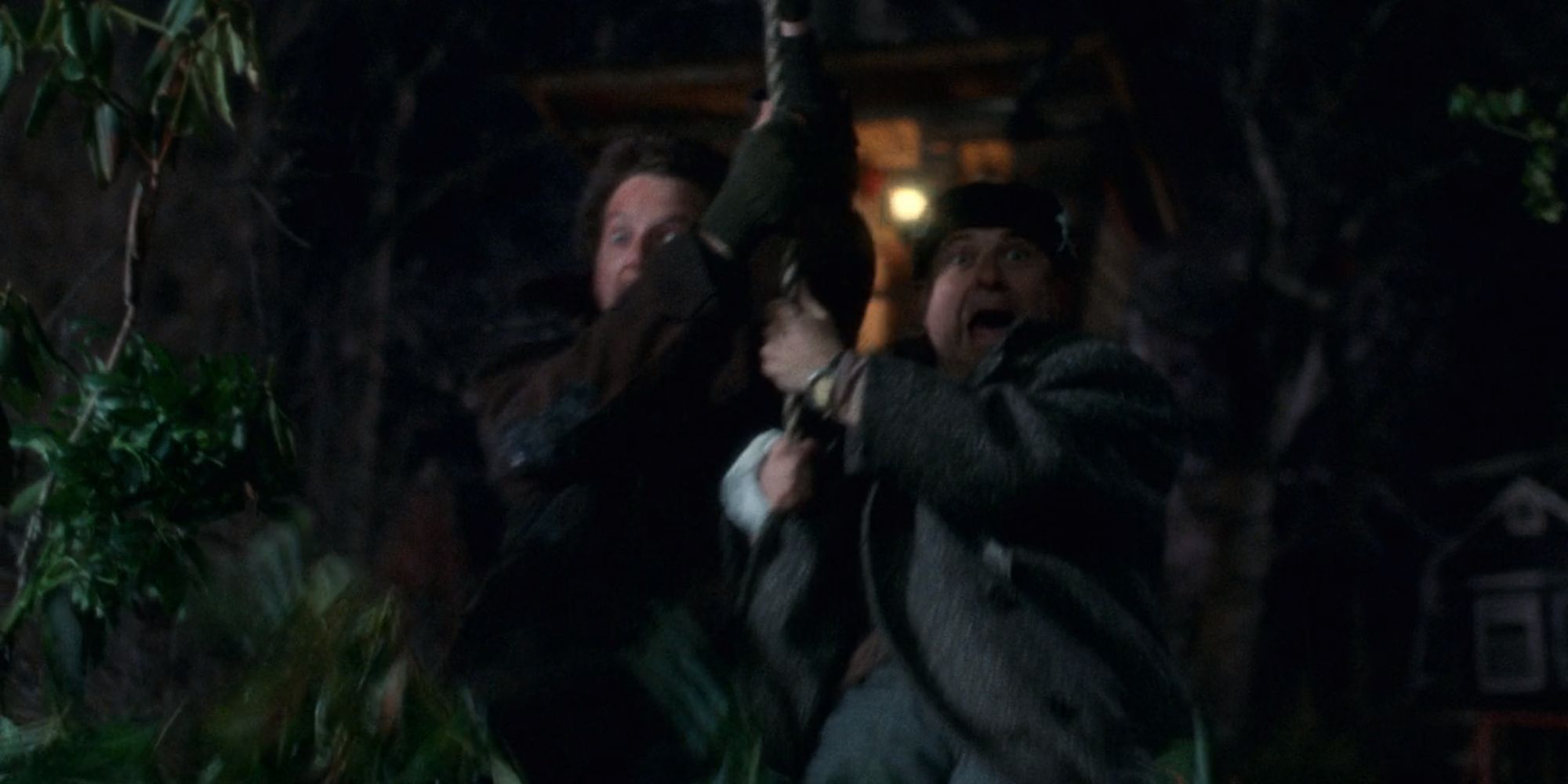 Harry and Marv swinging on a rope in Home Alone (1990)