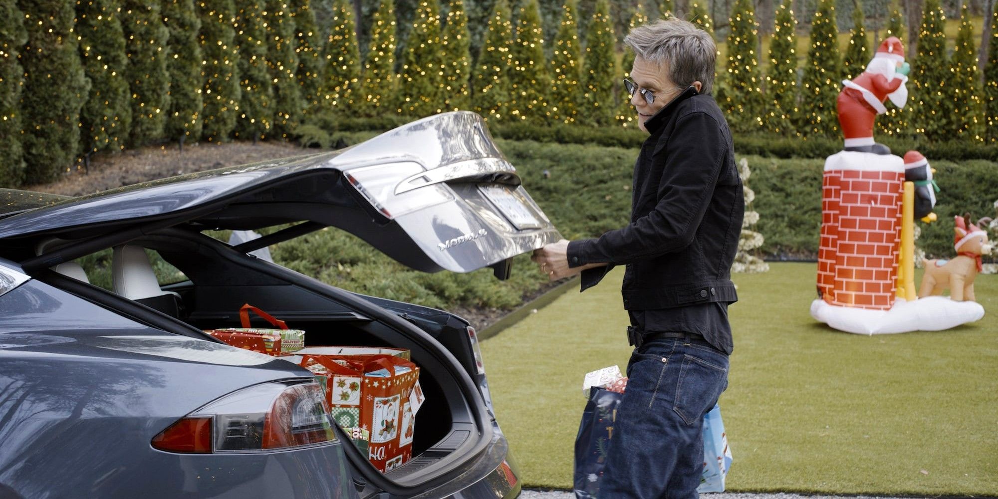 Kevin Bacon sebagai dirinya mendapatkan tas dari bagasi mobilnya di Guardians of the Galaxy Holiday Special