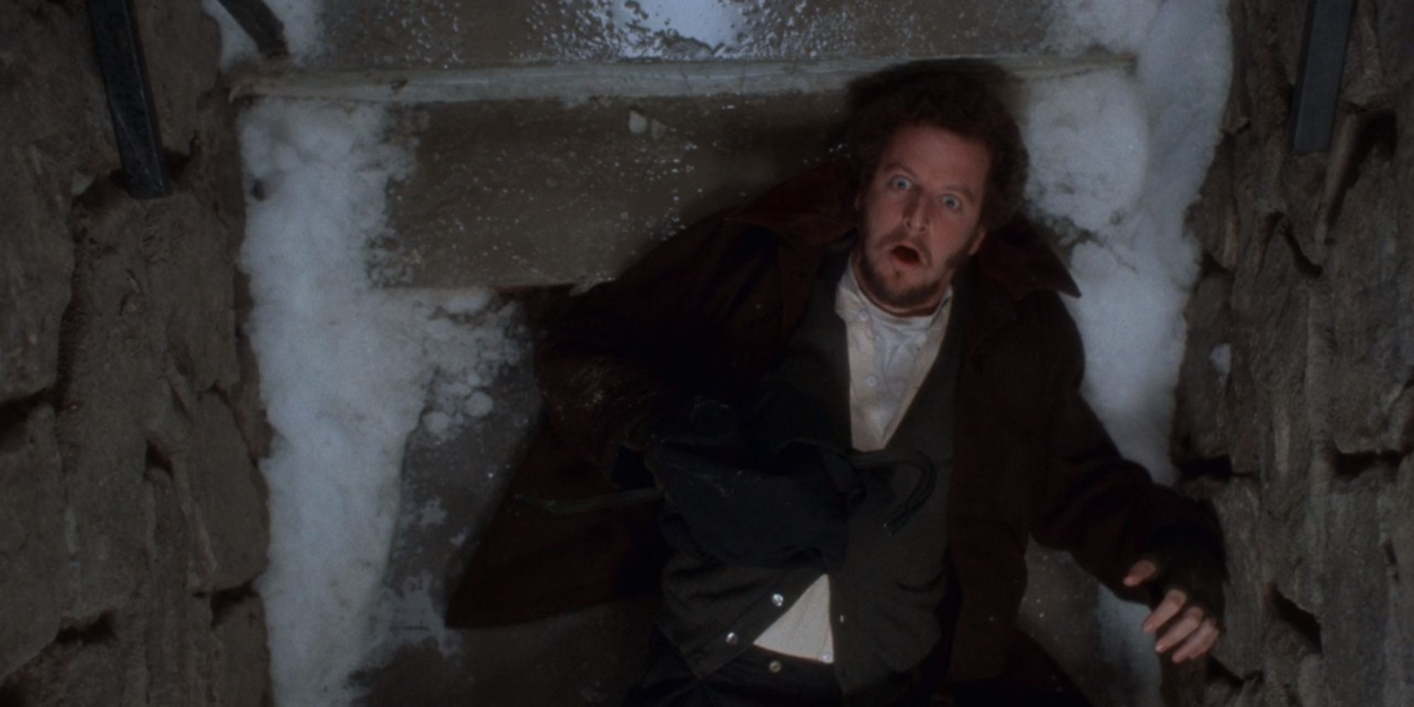 Marv deitado no fundo da escada gelada do porão em Home Alone (1990)