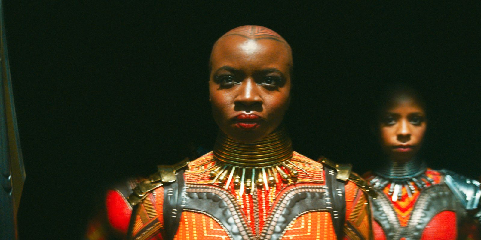 Uma imagem de Okoye parada no escuro em Wakanda Forever