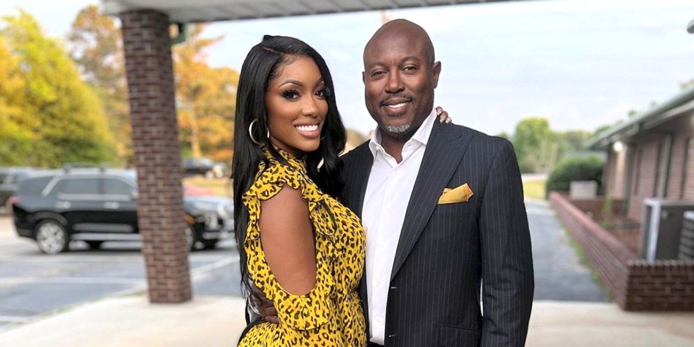 RHOA's Porsha Williams & Simon Guobadia posing together on the sidewalk outside a building