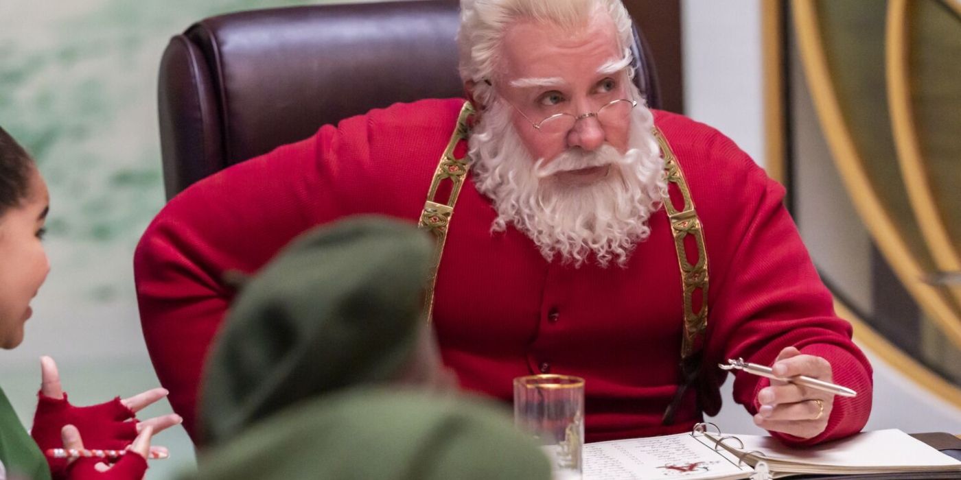 Scott/Santa sit at a desk at The Santa Clauses