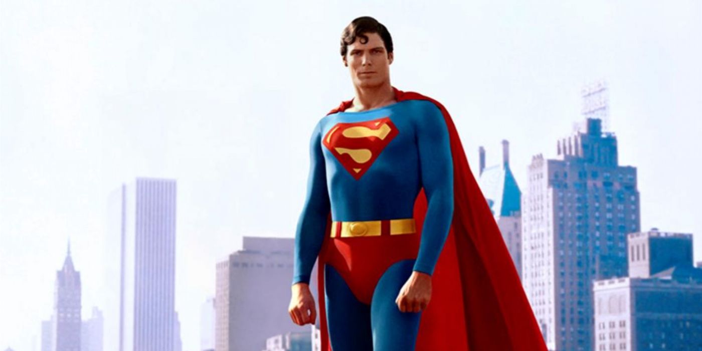 Christopher Reeve como Superman flutuando no céu com a paisagem urbana de Metrópolis atrás dele.