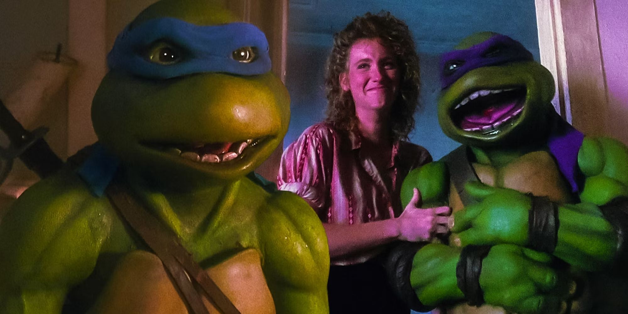 A blended image features Judith Hoag as April and two Ninja Turtles in the 90s live-action Teenage Mutant Ninja Turtles movies