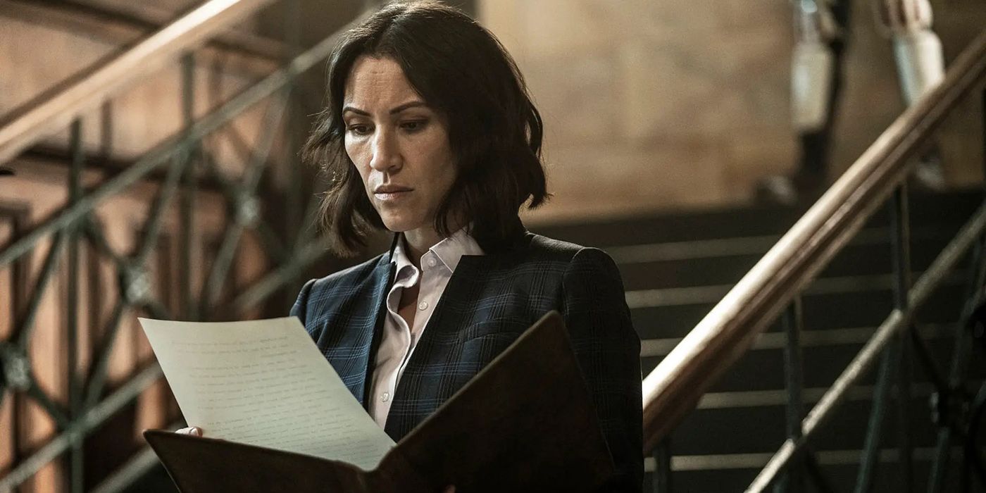 Yumiko from The Walking Dead in a suit, looking at papers.
