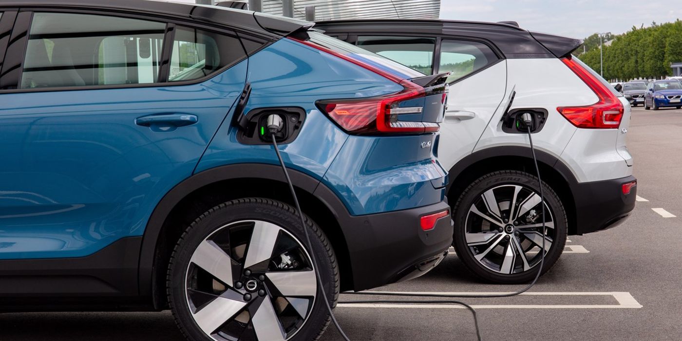 A photo of two Volvo electric vehicles with the charger plugged in.