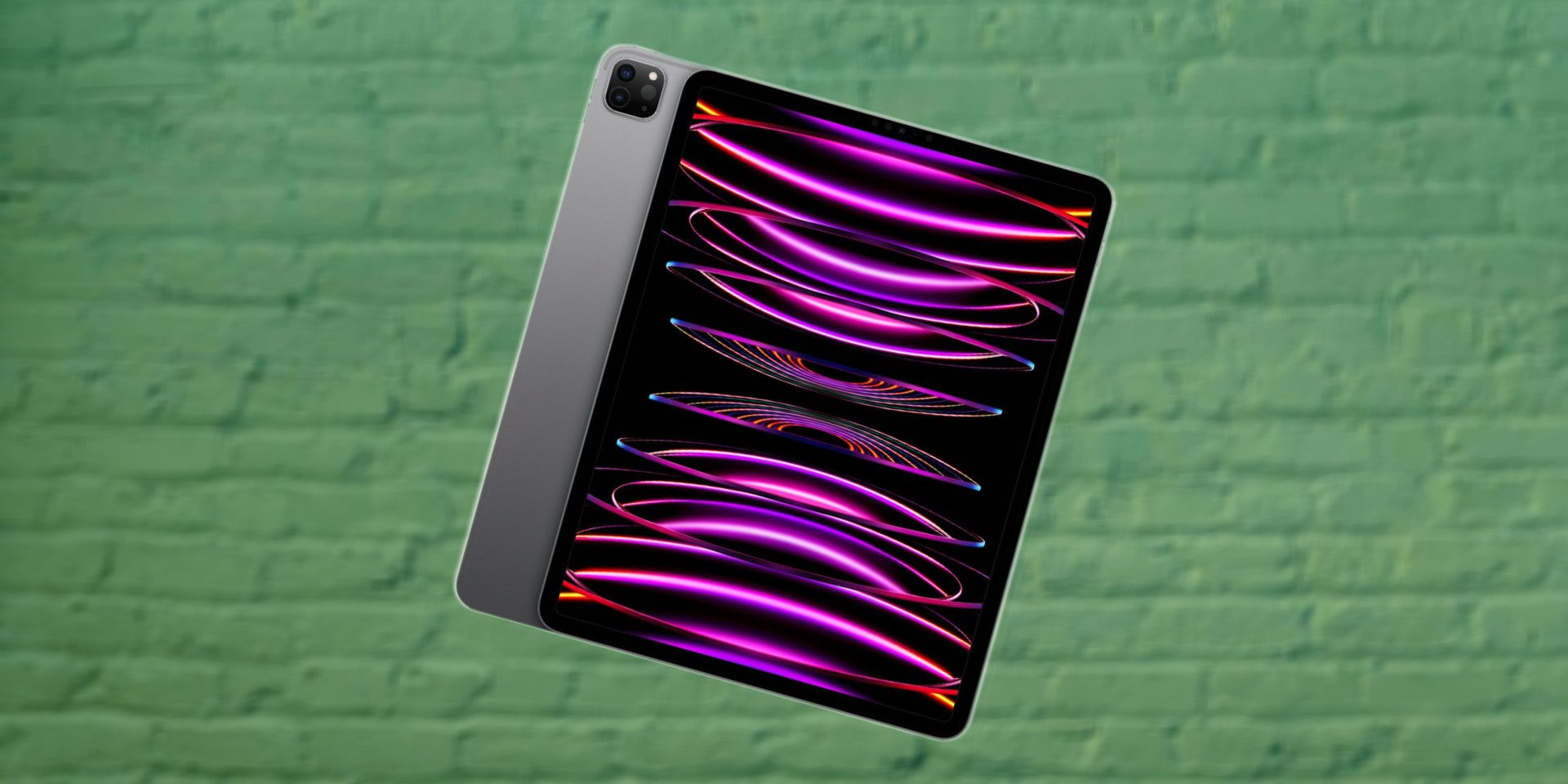 iPad Pro M2 12,9 pouces (2022) avec design radial rose et noir sur fond de brique verte floue